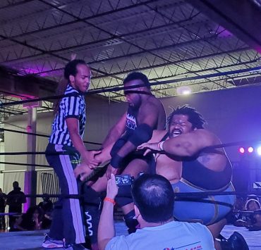 Wrestler attacks other wrestlers arm