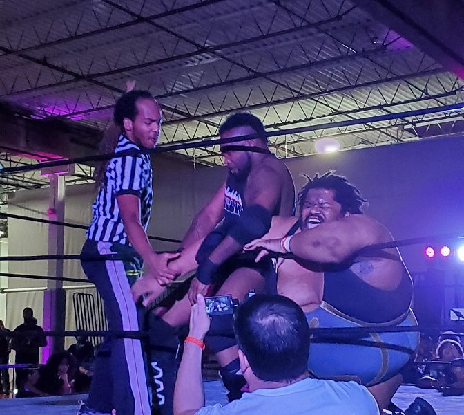 Wrestler attacks other wrestlers arm