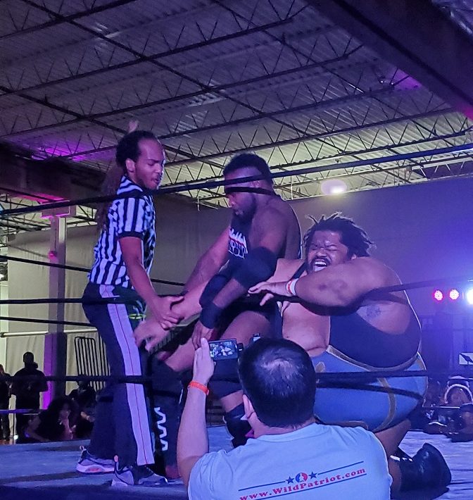 Wrestler attacks other wrestlers arm