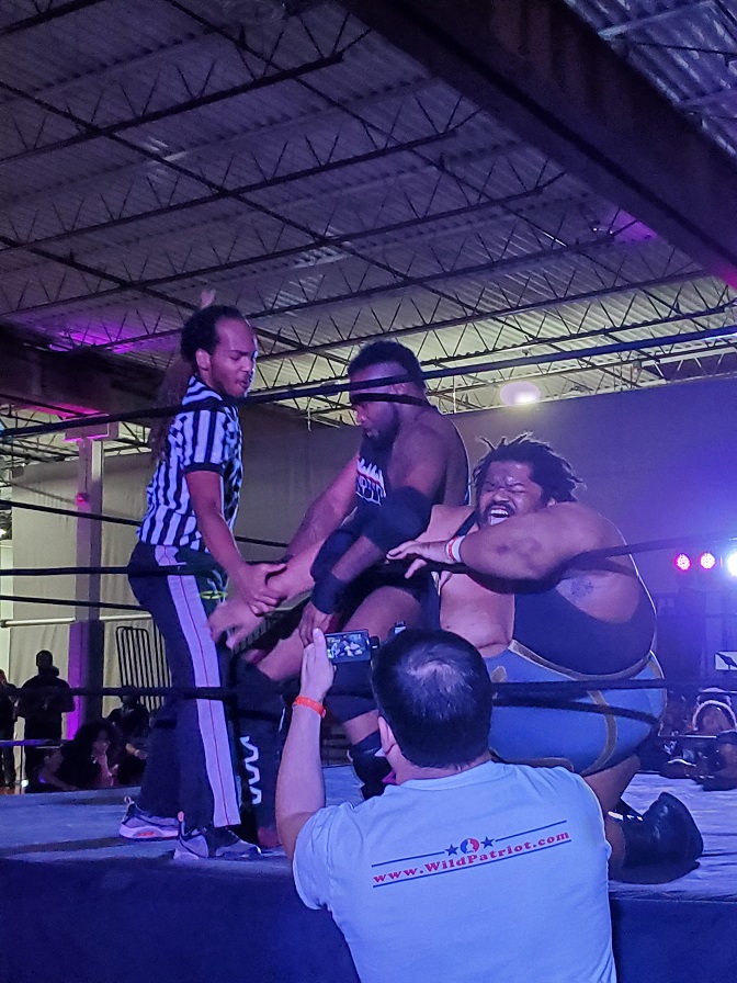 Wrestler attacks other wrestlers arm