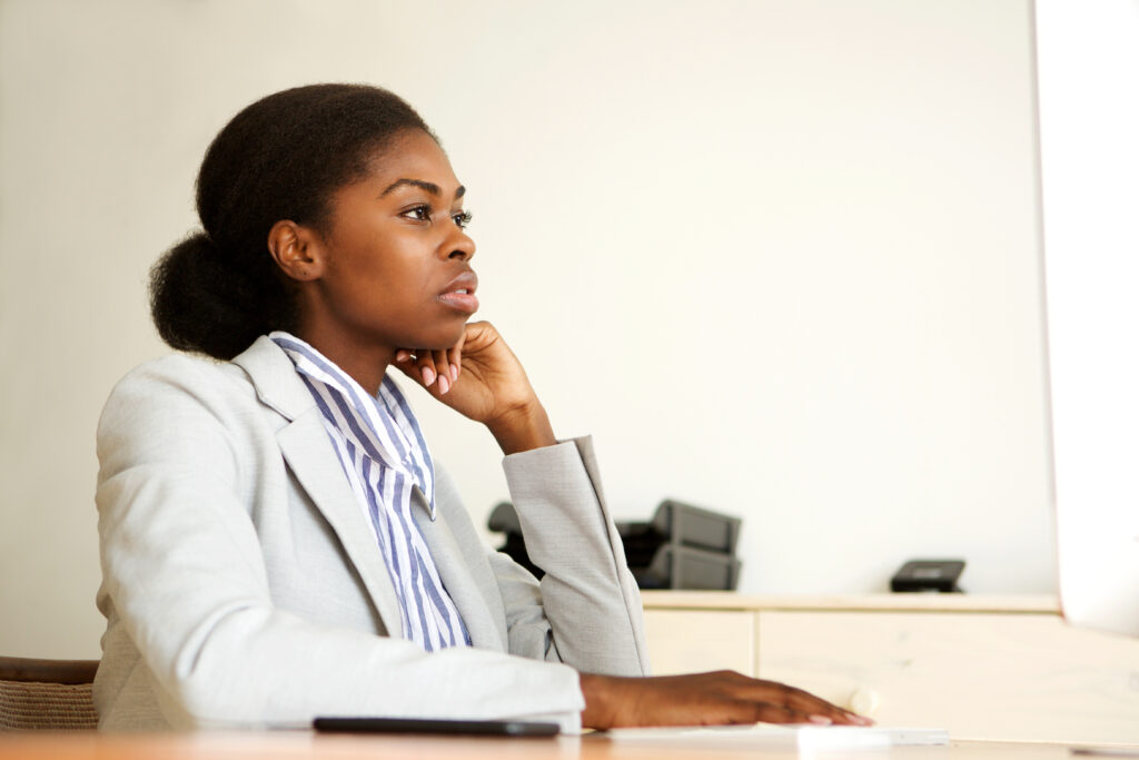 Black woman looking serious in office setting.